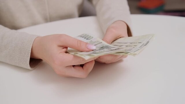 Female hands counting Czech koruna cash. Personal finance, budgeting, salary income and money management concept in Czech Republic.