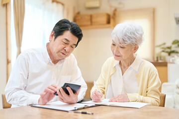 Fototapeta premium 家計の計算をするアジア人シニア夫婦