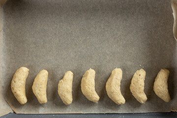 raw vanilla crescent cookies on baking tray  