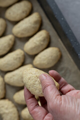 hand holding baked vanilla crescent cookie 
