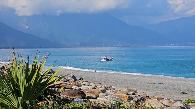 Small working fishing boats and utility vessels anchored along Hualien coastline, calm blue waters and traditional maritime livelihood scene under clear coastal sky in eastern Taiwan