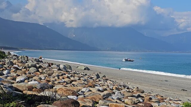 Small working fishing boats and utility vessels anchored along Hualien coastline, calm blue waters and traditional maritime livelihood scene under clear coastal sky in eastern Taiwan
