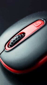 Extreme macro of a black and red computer mouse showing the textured scroll wheel and buttons in soft light&mdash;clean tech b-roll for productivity, gaming, and UI themes.