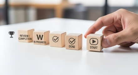 Agile development sprint and showing cubes moving through a short, focused work cycle using wooden cubes, symbolic icons, human hand, natural depth of field, soft blurred background, clean white desk.