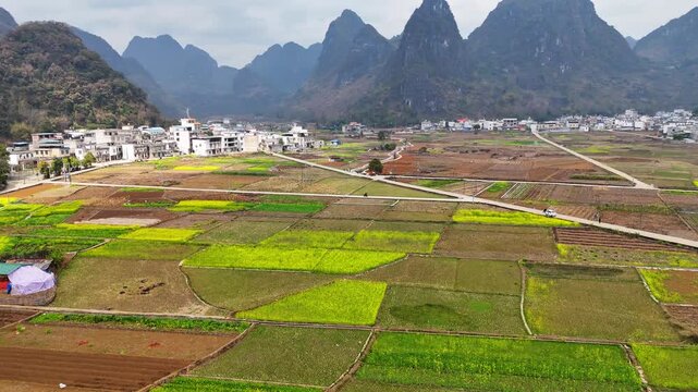 Morning Light Over Karst Countryside: Rapeseed Fields, Mountain Village, and Winding Roads