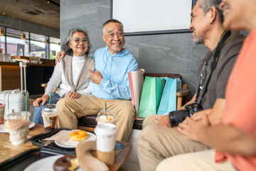 Obraz premium Group of happy senior asian friends talking and laughing together at cafe, Elderly couples enjoying coffee and bakery after shopping, active aging, senior travel, retirement lifestyle and friendship