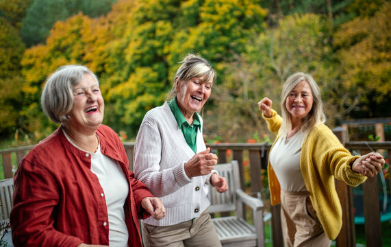 Three joyful senior women laughing together.