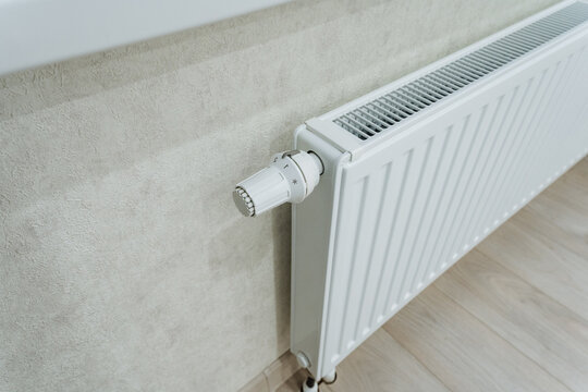 White Wall Radiator With Thermostat. Comfortable And Energysaving Heating Setup In Apartment. Sleek White Radiator With Thermostat For Improved Energy Efficiency And Cozy Ambiance