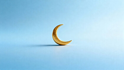 Obraz premium A golden crescent moon symbol on a blue background. Islamic holiday decoration for Ramadan and Eid al-Fitr. Minimalist concept with copy space