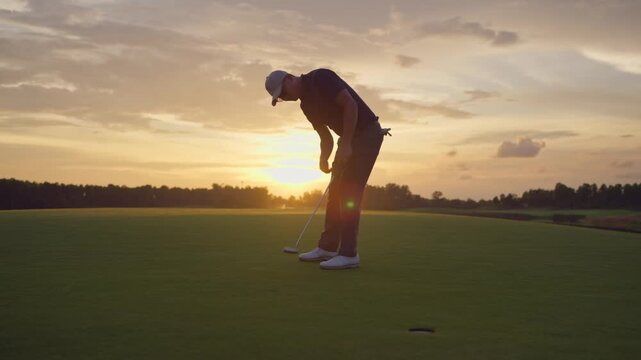 Professional young male golfer swings his club on scenic golf course. 