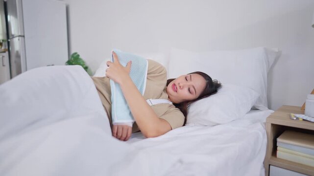 Injured Asian young woman wearing splint on hand in bedroom at home. 