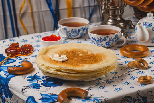 Pancakes on the table next to the samovar and caviar