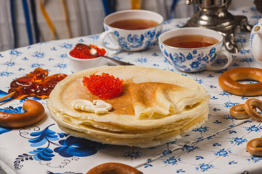 Pancakes on the table next to the samovar and caviar