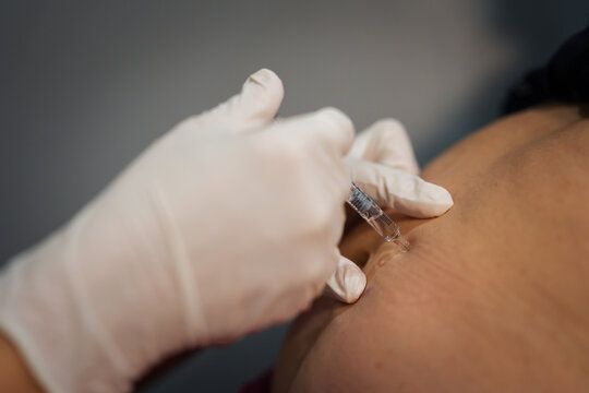 doctor is injecting enoxaparin injection to belly with syringe