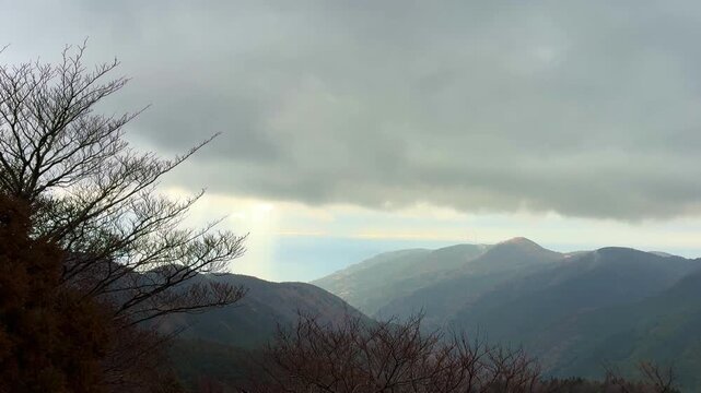 霧がかった山の向こうに光の帯が見える