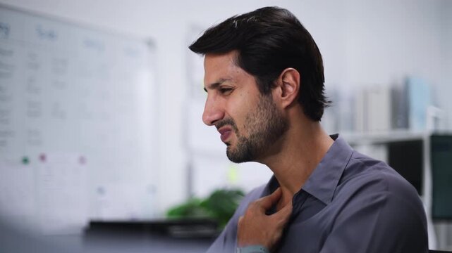 Man suffering from Sore throat and Throat Pain with Dry throat, feeling Sick due to Flu, Allergy or Dehydration while working in office.