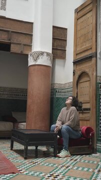 Woman walking through traditional Moroccan riad courtyard