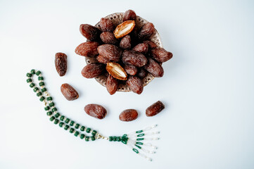 Fototapeta premium Simple clean flat lay for Ramadan with dates and green prayer beads