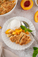 Homemade summer peach cobbler. Pie with juicy peaches, a scoop of vanilla ice cream and fresh mint...
