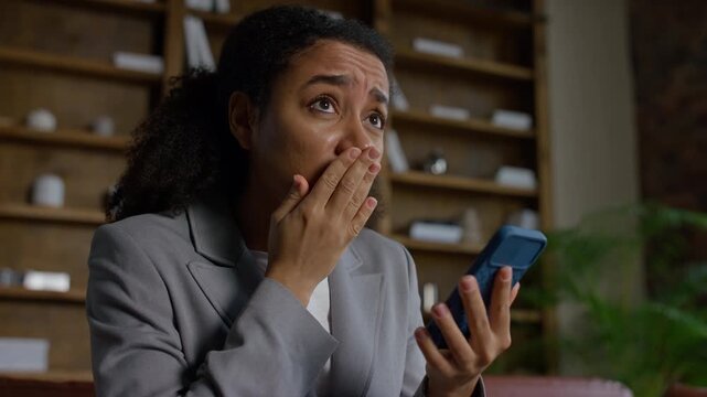 Shocked Businesswoman Reading Layoff Message on Phone