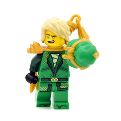 Fototapeta premium Editorial illustrative image of lego minifigure of green ninja Lloyd with golden blade or sword weapon isolated on white. Jubilee 15 years of lego Ninjago.