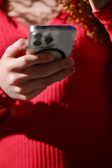Woman Using Smartphone With Curly Hair Wearing Red Sweater IndoorsDays