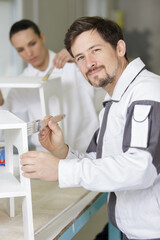 Fototapeta premium happy men with a brush paints the wood surface