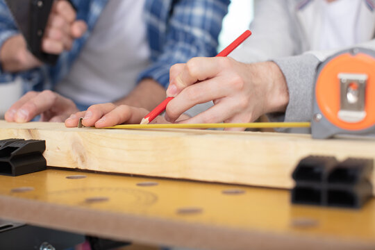 male hands with measuring tape new laminated wooden floor
