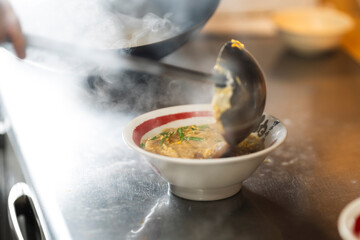 Chef Preparing Ramen in Japanese Noodle Shop with Steam Rising