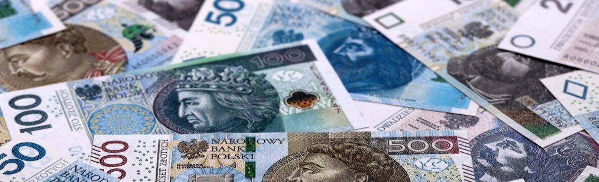 Polish zloty money bills pile on table. Poland banknotes of PLN currency close up.