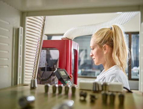 Female technician maintaining CNC machine