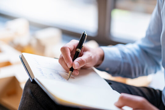 Close-up of businessman taking notes in office