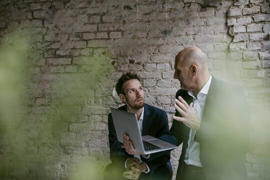 Senior and mid-adult businessman having a meeting using laptop