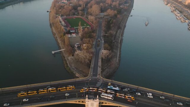Breathtaking drone footage of the Margaret Bridge that straddles across the Danube River in Budapest Hungary. Trams can be seen crossing the bridge amidst the busy traffic.