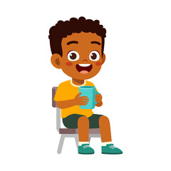 An adorable happy African American boy sitting smiling and holding a blue mug in a cheerful moment