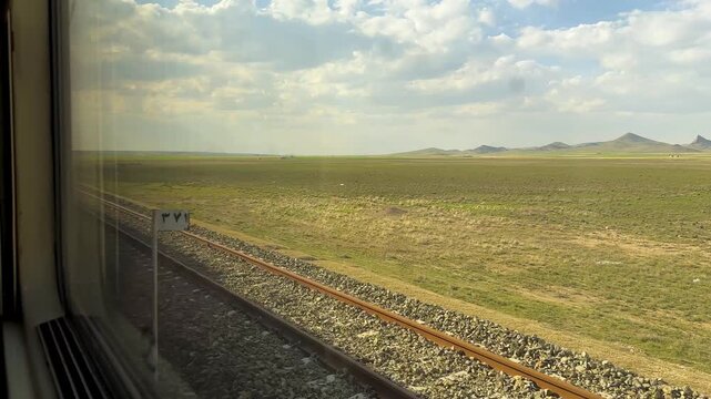 iron railway with parallel lines in Iran shiraz countryside agriculture fields rice paddy wheat rural landscape panoramic cinematic travel journey train road trip daytime greenery industrial transport