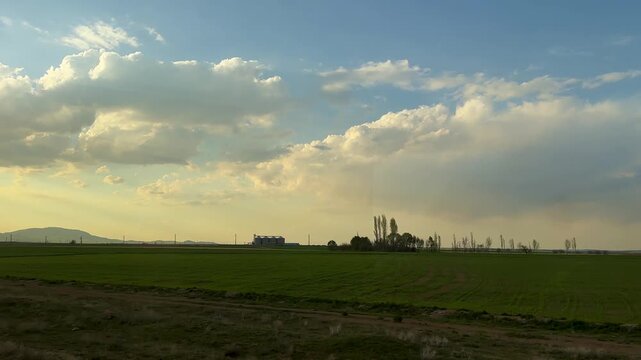 train window landscape in Iran countryside agriculture harvest season wheat grain barley cereal farmland green fields farming corn crop storage in silage metal tower rural scenic aerial cloudy sky