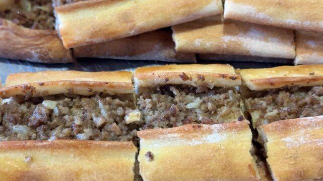 Turkish pide with minced meat filling on metal surface as close-up food background