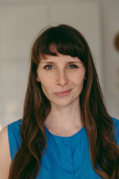 Woman with bangs smirking while looking at camera