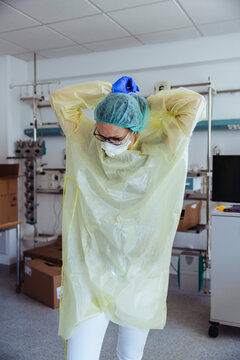 Doctor taking off personal protective equipment in hospital
