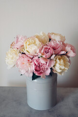 Beautiful bouquet of fresh colorful peonies in full bloom in vase. Floral spring still life.