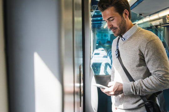Young man using smartphone on a train
