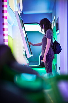 Woman at touchscreen in an amusement arcade