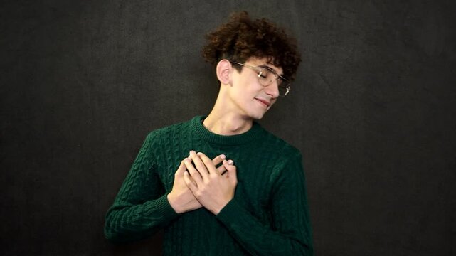 The man grimaces and points with his hands and finger.