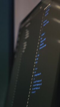 Close-up of a computer monitor showing lines of code in a dark-themed IDE with syntax highlighting.