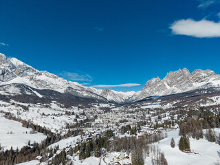 Sunny Winter Aerial Panorama of Cortina d'Ampezzo with Snowy Tofane Mountains, Dolomites, Italy