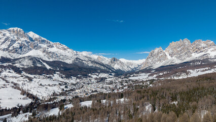 Sunny Winter Aerial Panorama of Cortina d'Ampezzo with Snowy Tofane Mountains, Dolomites, Italy