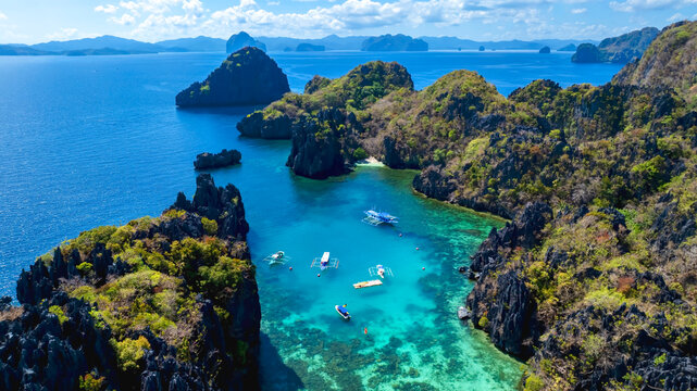 Aerial view of a beautiful tropical island with crystal clear water with limestone cliffs as the beach, Coron, Palawan, Philippines.