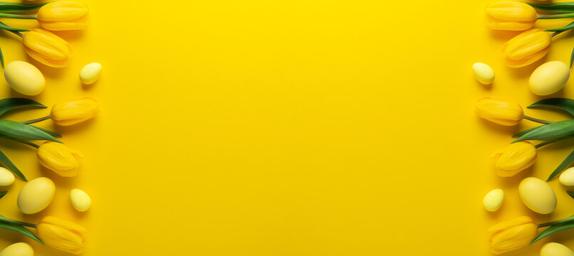 Happy Easter holiday background. Yellow Easter eggs and tulip flowers on yellow background top view. Greeting card, frame, banner. Spring theme.