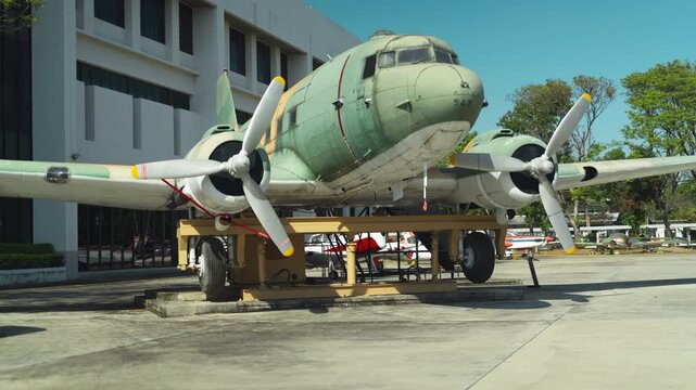 An old aluminum propeller aircraft stands on the site with engines muffled. Retro aviation.